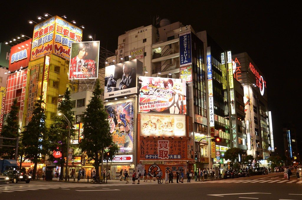 Calle de Akihabara de noche, con carteles luminosos de anime