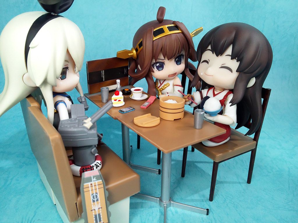 Figuras Nendoroid sentadas a una mesa en miniatura